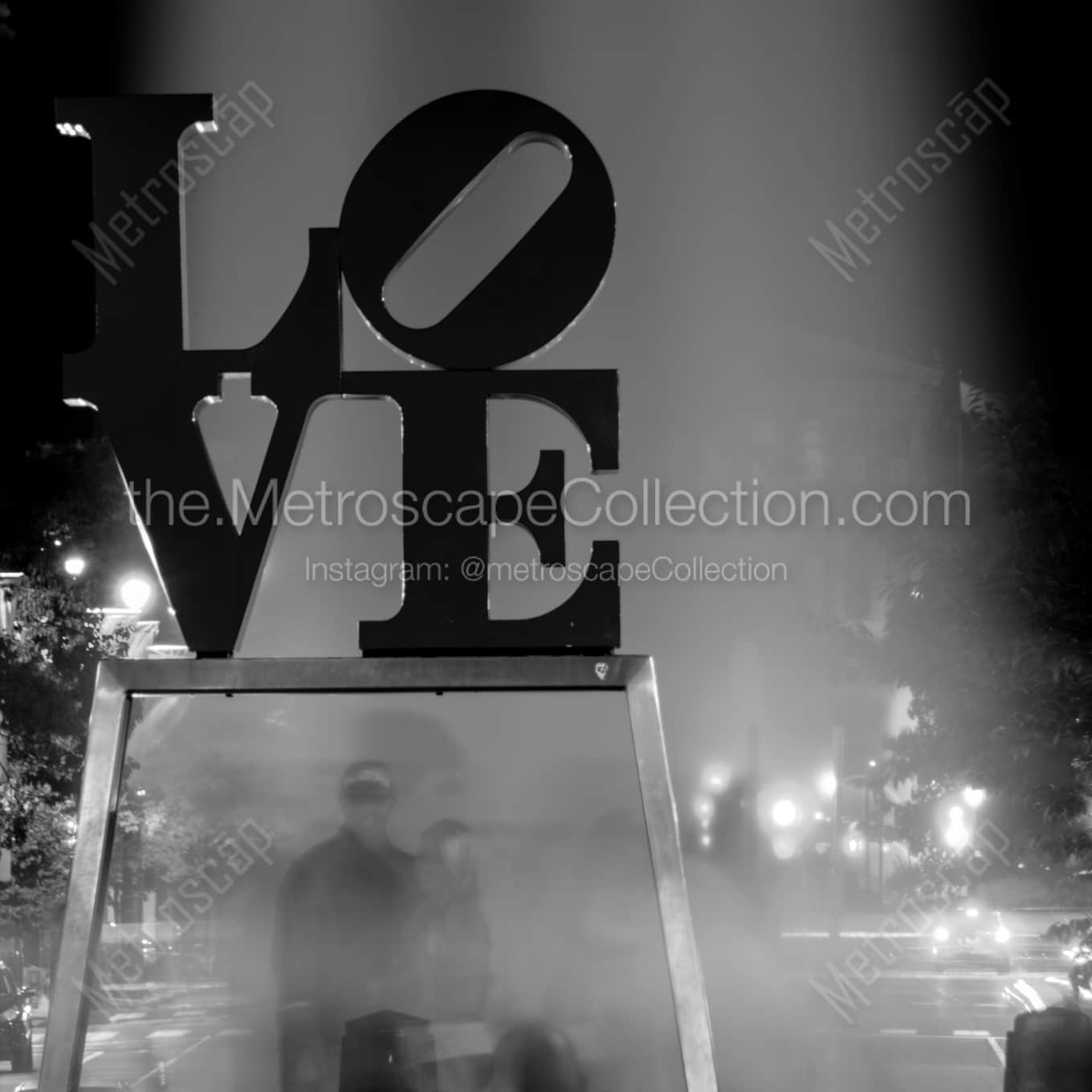 Couples Pose Under the Love Sculpture night time black and white Photography square crop