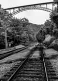 Vertical The New River Gorge Bridge over Railroad Tracks black and white Photos