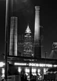 Vertical The Key Bank Building is Framed by Smoke Stacks from the Rock Bottom Brewery black and white Photos