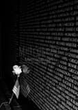 Vertical A Rose and American Flag Leans Against the Vietnam Wall black and white Photos